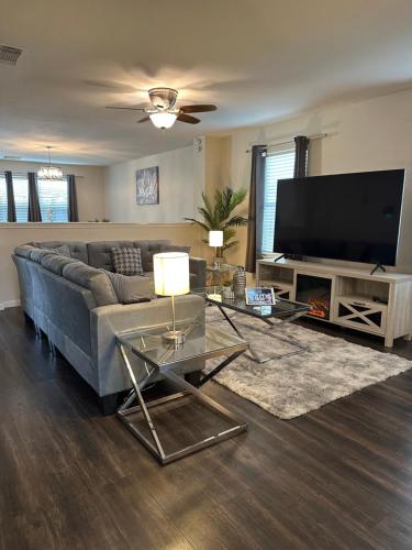 a living room with a couch and a flat screen tv at Huge Captivating Modern 5Bdr home-(The Xperience) in Cypress
