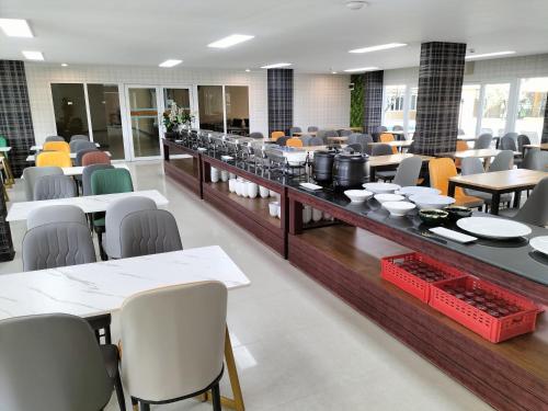 a dining room with tables and chairs and a cafeteria at H2DO Hotel in Ban Khlong Sanam Phli