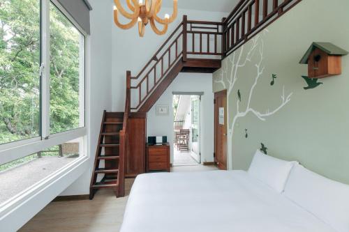 ein Schlafzimmer mit einem großen Bett und einer Treppe in der Unterkunft Reindeer Miaoli Green Wave in Sanyi