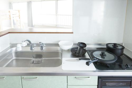 a kitchen with a sink and a stove at AIRSTAR TENJIN パインヒル警固505 - Apartment stay in Fukuoka