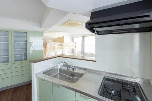 a kitchen with a sink and a stove at AIRSTAR TENJIN パインヒル警固505 - Apartment stay in Fukuoka