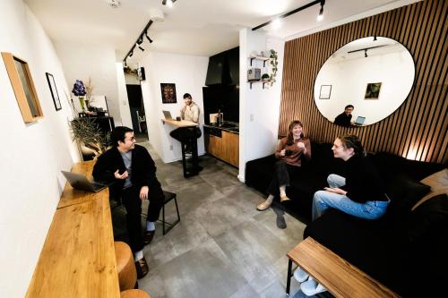 a group of people sitting in a living room at Eden House in Tokyo