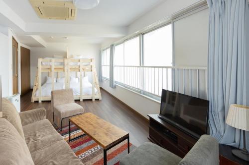 a living room with a couch and a television and a bed at AIRSTAR TENJIN パインヒル警固505 - Apartment stay in Fukuoka