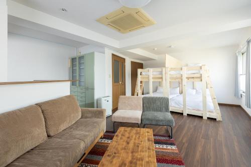 a living room with a couch and two bunk beds at AIRSTAR TENJIN パインヒル警固505 - Apartment stay in Fukuoka