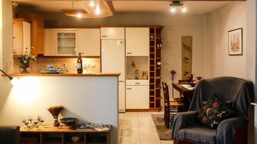 a kitchen and a living room with a table and chairs at Artemis Apartment,Beach two-bedroom in Artemida