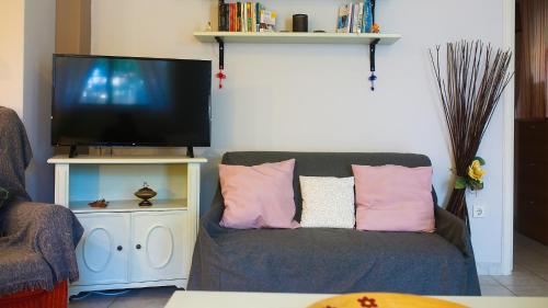 a living room with a couch and a tv at artemis homest ay ,two-bedroom apartment in Artemida