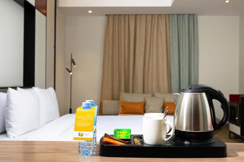 a hotel room with a coffee maker on a tray next to a bed at Ewaa Express Hotel - Al Jouf in Sakakah