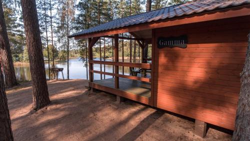 a cabin in the woods with a view of a lake at Kempings Bejas in Babīte