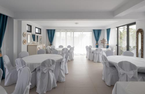 a banquet hall with white tables and chairs in a room at Light Blue Hotel in Nea Kalikratia