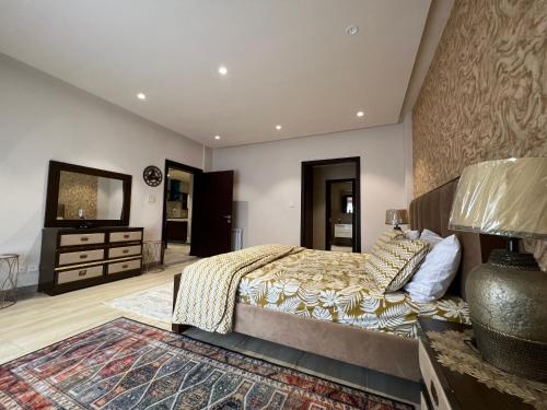 Schlafzimmer mit einem Bett, einer Kommode und einem Spiegel in der Unterkunft 1 Bed Luxurious Apartment at Bahria Heights 5 in Rawalpindi