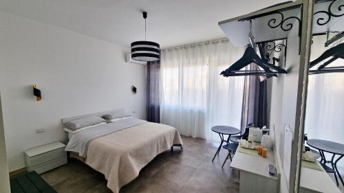 sypialnia z łóżkiem, stołem i krzesłami w obiekcie MERIDIAN B&B w Syrakuzach