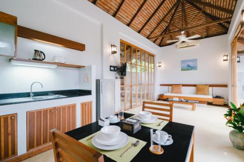 a kitchen and dining room with a table and chairs at Bor Saen Pool Villa in Bor Saen