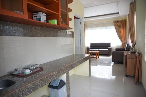 a kitchen with a sink and a living room at Griya Kayana Inn and Villas in Bogor