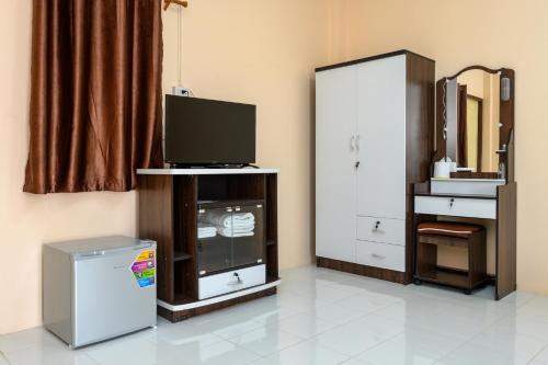 a living room with a television and a refrigerator at Beung Sampathuan Nakornchaisri Resort in Ban Laem Bua