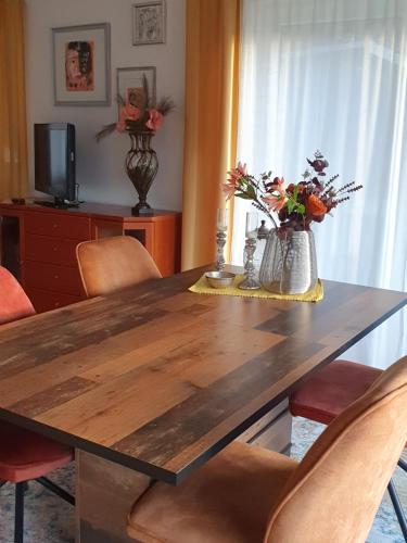 a dining room with a wooden table and chairs at 2 Zimmer Domizil am Südhang mit Terrasse und Pool in Ortenberg