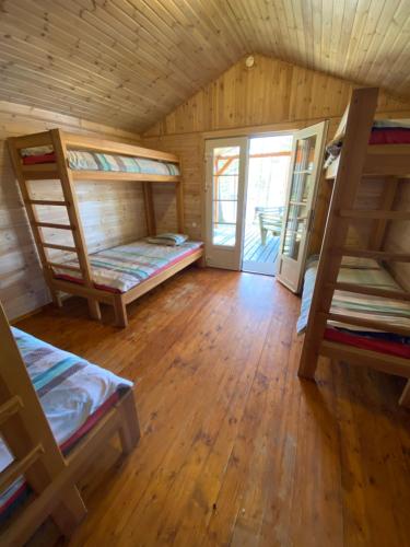 a room with three bunk beds and a door at Kempings Bejas in Babīte