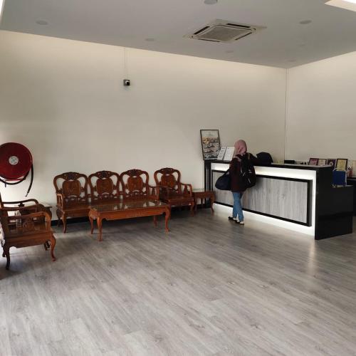 a woman standing in a room with chairs at Hotel K T Mutiara in Kuala Terengganu