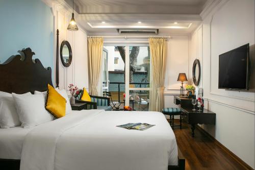 a bedroom with a large white bed and a desk at San Boutique Hotel in Hanoi