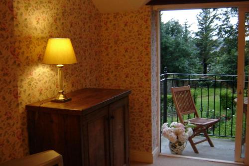 a lamp sitting on a table next to a sliding glass door at Woodhill House in Ardara