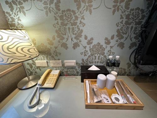 a room with a desk with a lamp and a tray of items at 銀座飯店Ginza Hotel in Taipei