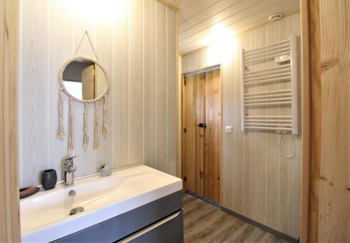 une salle de bain avec un lavabo et un miroir dans l'établissement Au cœur du jardin, à La Boussac