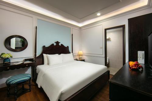 a bedroom with a bed and a desk and a mirror at San Boutique Hotel & Travel in Hanoi