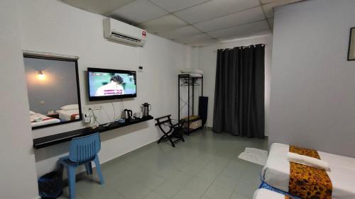 a room with a bed and a tv in a room at Hotel K T Mutiara in Kuala Terengganu