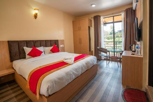 a bedroom with a large bed with red pillows at Hotel Atithi Satkar in Nagarkot