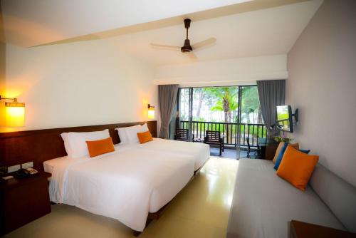 a bedroom with a large white bed and a balcony at Grand Southsea Khaolak Beach Resort in Khao Lak