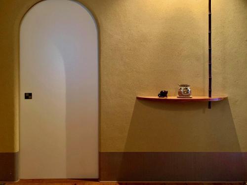 a hallway with a shelf and a white wall at unsui 武雄蓬莱町 雲水 in Takeo