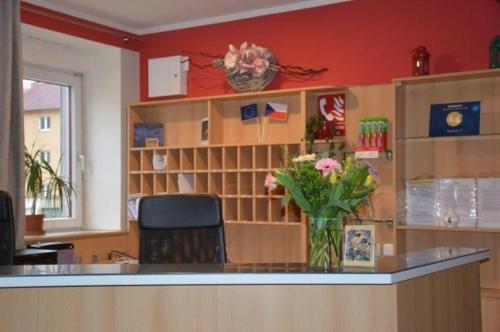 a lobby with a counter with a vase of flowers at Hotel O.K. 1 in Beroun