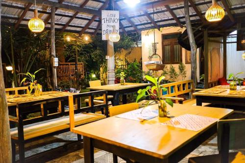 a restaurant with wooden tables and chairs and lights at Lala's Place in Galle