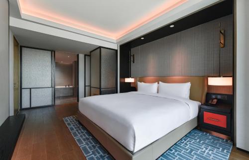 a bedroom with a large white bed in a room at Empark Grand Hotel Beijing in Beijing