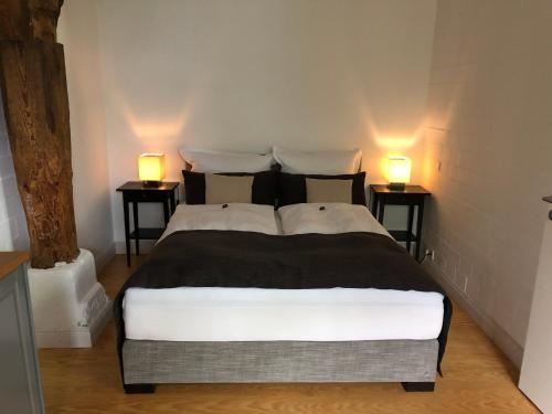 a bedroom with a bed with two lamps on two tables at Bielenberg 37 in Kollmar