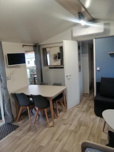 a living room with a table and chairs and a couch at MHVACANCES LOUENT PLUSIEURS MOBILHOMES DANS CAMPING 4 ETOILES PROCHE CHATEAUX et ZOO BEAUVAL in Onzain