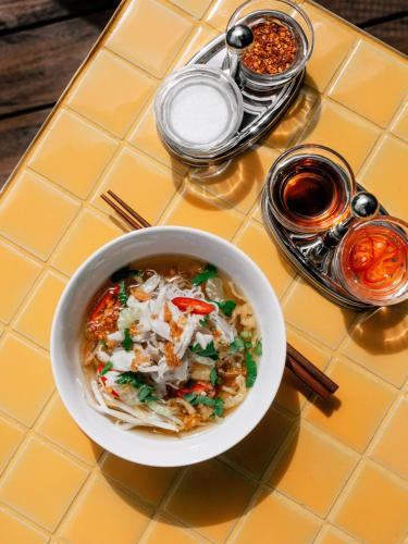 a bowl of food on a table with a plate of food at The Standard, Bangkok Mahanakhon in Bangkok