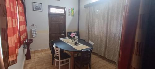 a small table and chairs in a room with a door at Tito's Homestay in Kalimpong