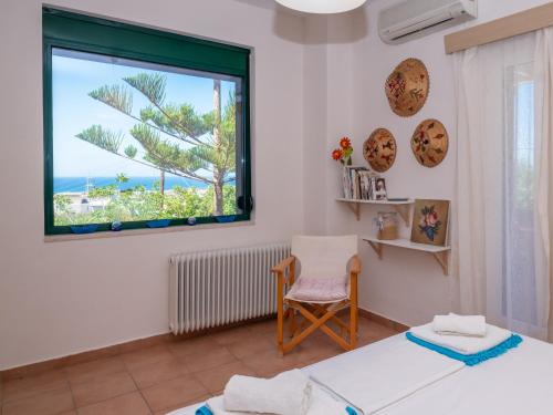 a bedroom with a window with a view of the ocean at Villa Verde in Malia