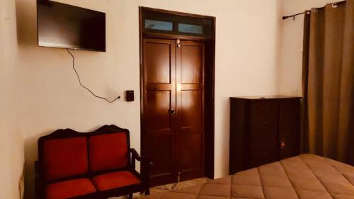 um quarto com uma cama e uma televisão na parede em Casa Adiel em Campeche
