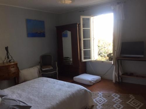 une chambre avec un lit, une fenêtre et une télévision dans l'établissement es aqui, à Souvignargues