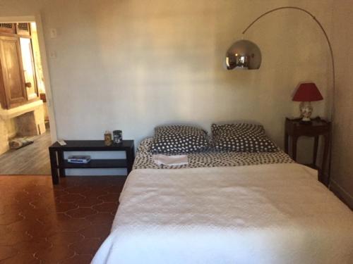 une chambre avec un grand lit et une lampe dans l'établissement es aqui, à Souvignargues