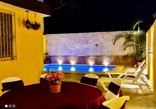 a room with a table and chairs and a pool at Casa Adiel in Campeche