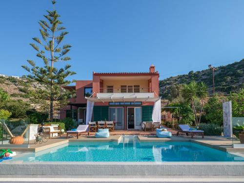 a villa with a swimming pool in front of a house at Villa Verde in Malia