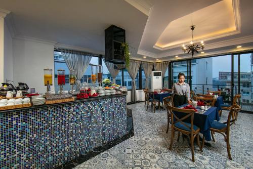 a woman standing at a buffet in a restaurant at San Boutique Hotel & Travel in Hanoi
