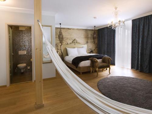 a hammock in a bedroom with a bed at DORMERO Hotel München-Kirchheim Messe in Kirchheim