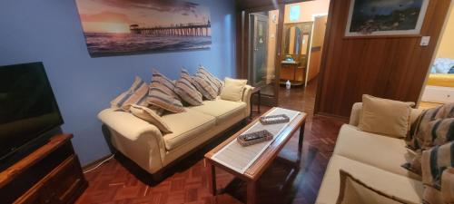 a living room with two couches and a television at Cottage by the Sea in Port Adelaide
