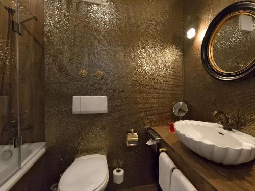 a bathroom with a sink and a toilet and a mirror at DORMERO Hotel München-Kirchheim Messe in Kirchheim