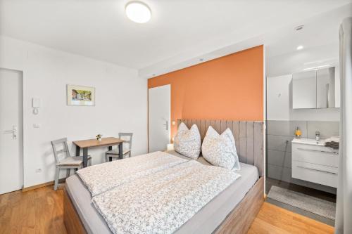 1 dormitorio con 1 cama grande y pared de color naranja en Hallstatt Lakeside Top 4 - Zimmer mit Balkon, en Hallstatt