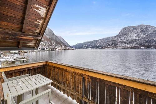a balcony with a chair and a view of the water at Hallstatt Lakeside Top 4 - Zimmer mit Balkon in Hallstatt