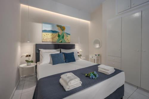 1 dormitorio con 1 cama grande y toallas. en Myra Mare Suites by Estia en Amoudara Herakliou